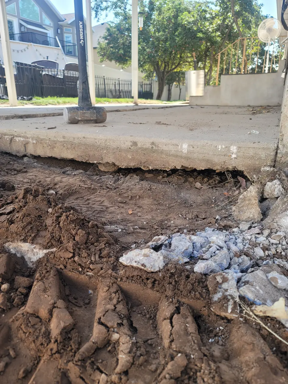 Failing concrete slab from another contractor, dug out for removal and replacement