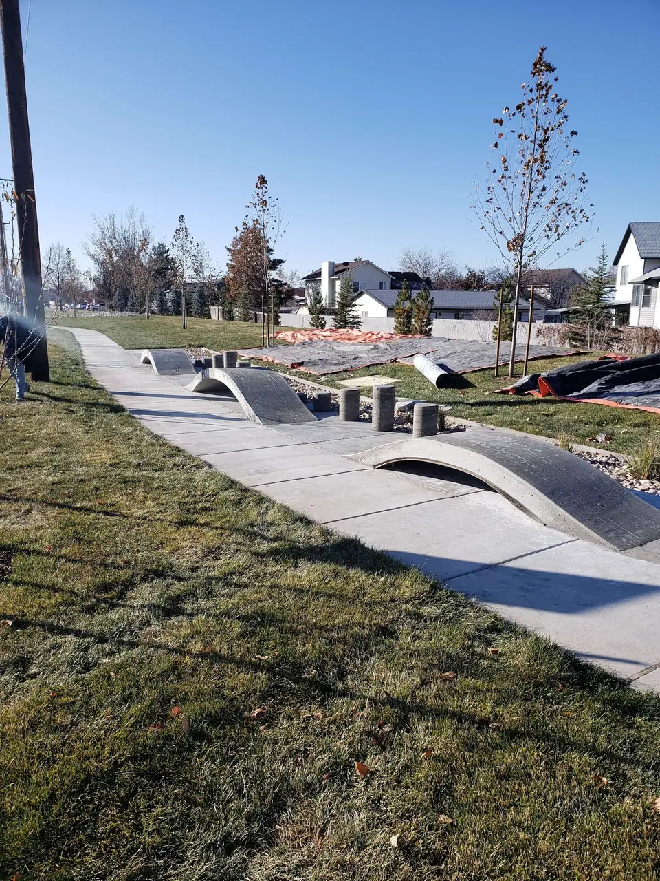 Concrete path with built-in mounds and features in a grassy field