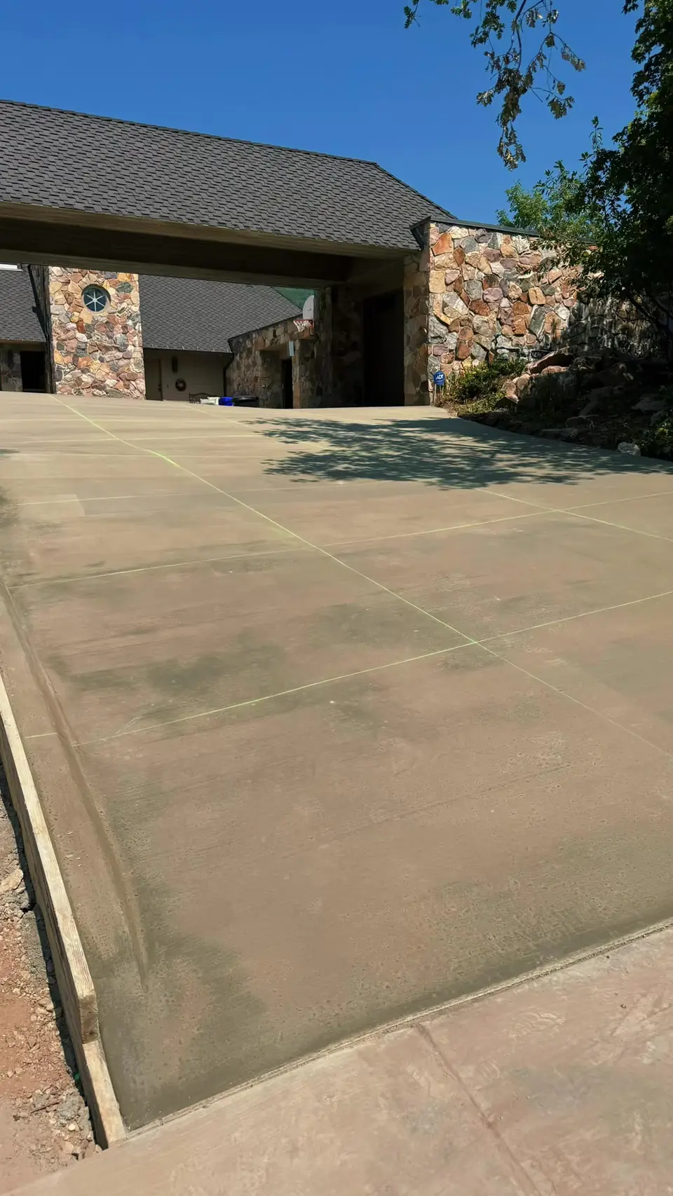 Freshly poured concrete driveway with joint lines, ready for winter snow-melt
