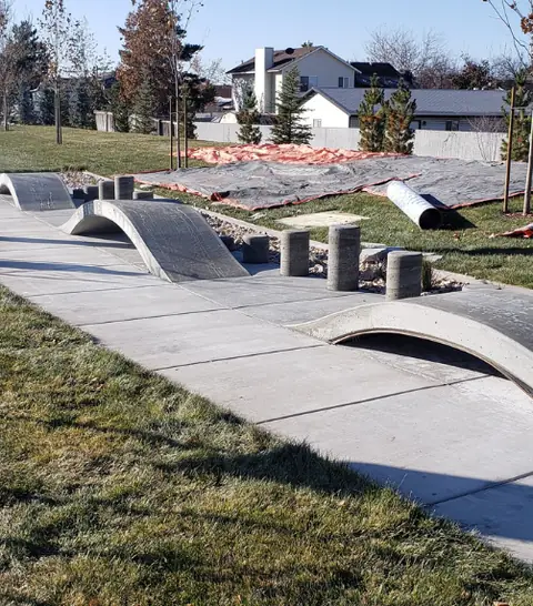 Curved concrete ramp features beside a new walkway, Syracuse City Ramps