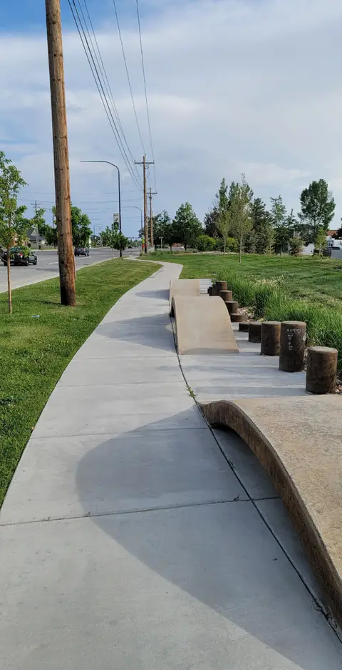 Finished concrete path with curved ramp features along a road, Syracuse City Ramps